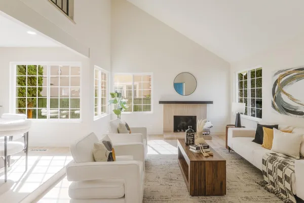 a living room with furniture a fireplace and a large window