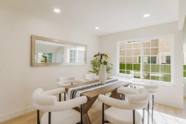 a dining room with furniture and a large window