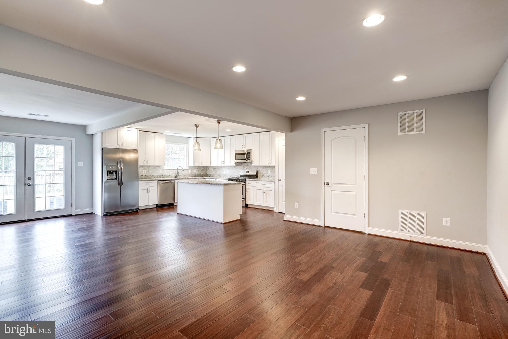 4121 Lees Corner Road Chantilly, VA 20151 - Photo 5 of 28 a view of an empty room with wooden floor and a kitchen