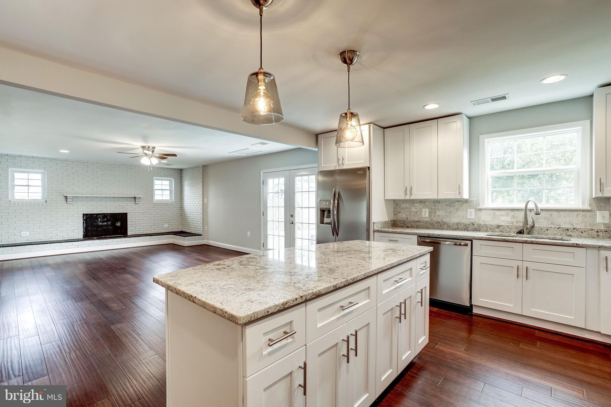 4121 Lees Corner Road Chantilly, VA 20151 - Photo 8 of 28 a kitchen with kitchen island granite countertop a sink appliances and wooden floor