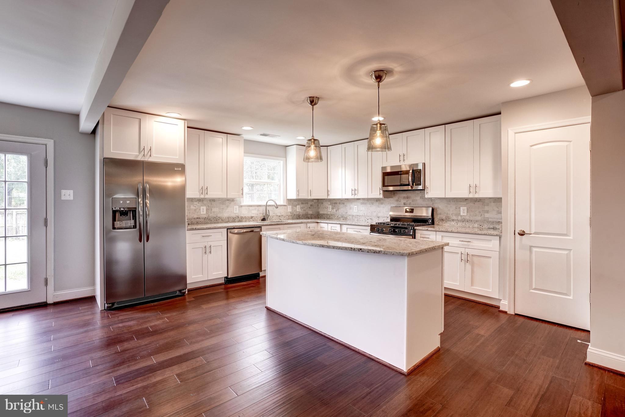 4121 Lees Corner Road Chantilly, VA 20151 - Photo 9 of 28 a kitchen with stainless steel appliances granite countertop a refrigerator a sink dishwasher a stove and white cabinets with wooden floor