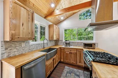 a kitchen that has a sink a stove and a wooden floors