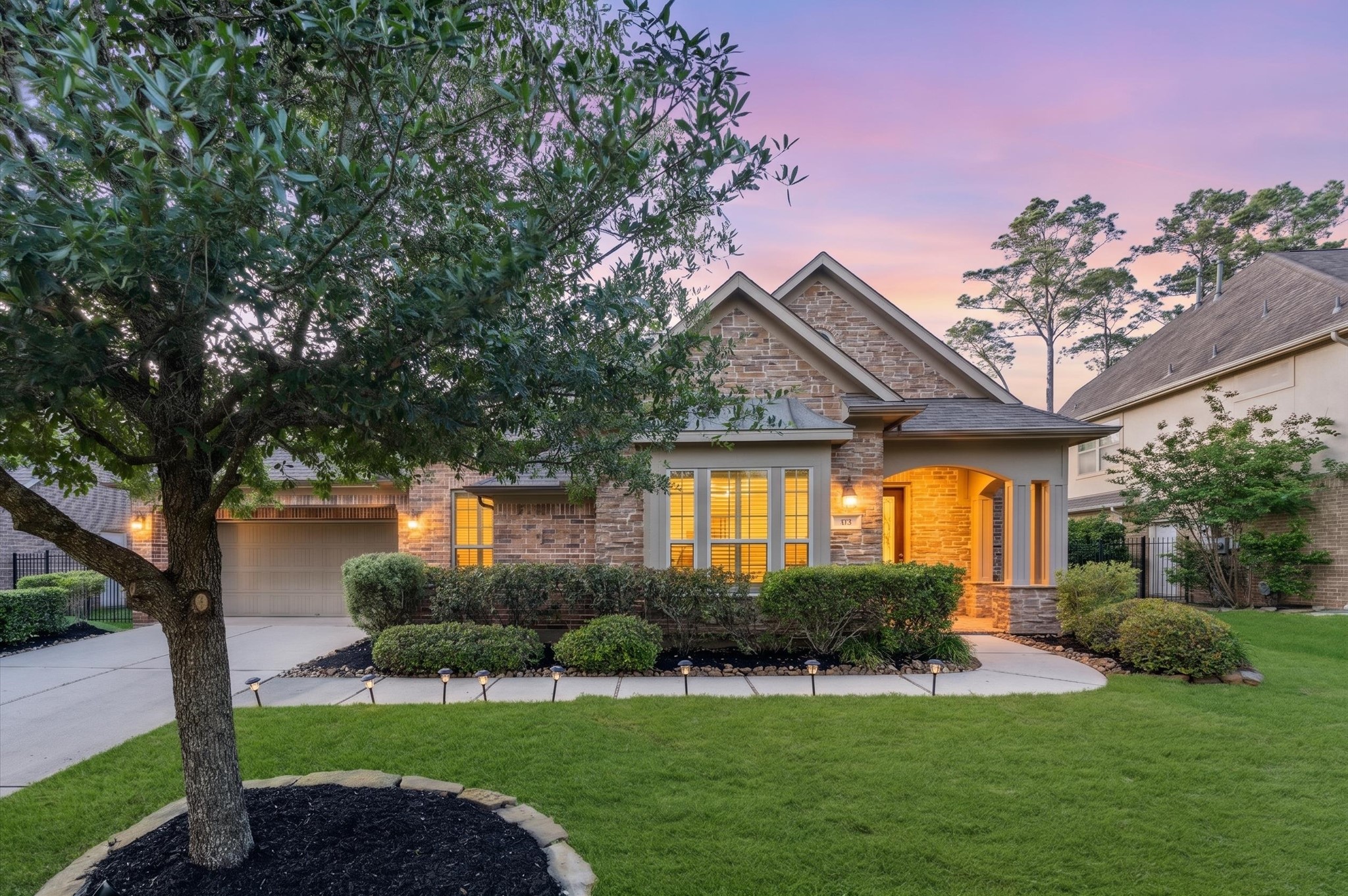 70 Valera Ridge Drive Spring, TX 77389 - Photo 1 of 37 Charming single-story home with a welcoming entrance, featuring a brick and stone exterior. A well-maintained lawn and mature trees enhance curb appeal. The driveway leads to a two-car garage, and the cozy front porch offers a warm, inviting feel.