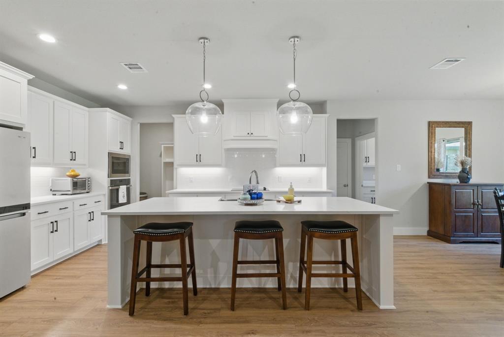 247 Gopher Road Weatherford, TX 76088 - Photo 11 of 35 a kitchen with stainless steel appliances granite countertop a table chairs sink and cabinets
