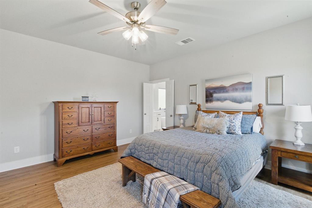 247 Gopher Road Weatherford, TX 76088 - Photo 13 of 35 a bedroom with a bed and a chandelier