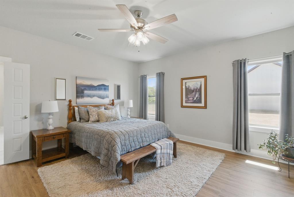 247 Gopher Road Weatherford, TX 76088 - Photo 14 of 35 a bedroom with a large bed and a chandelier