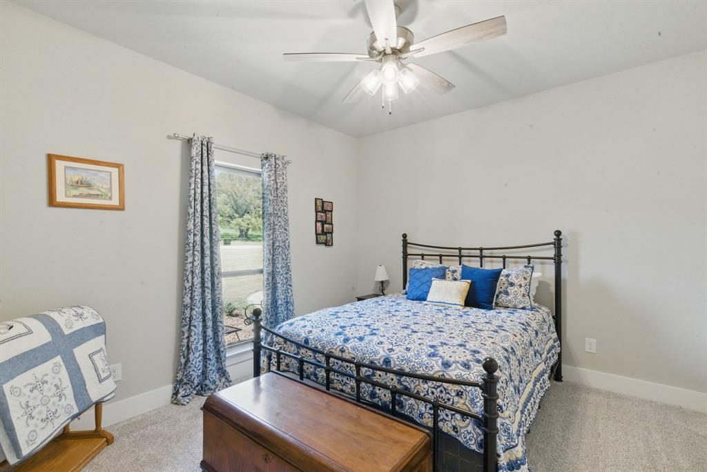 247 Gopher Road Weatherford, TX 76088 - Photo 20 of 35 a bedroom with a bed and a chandelier