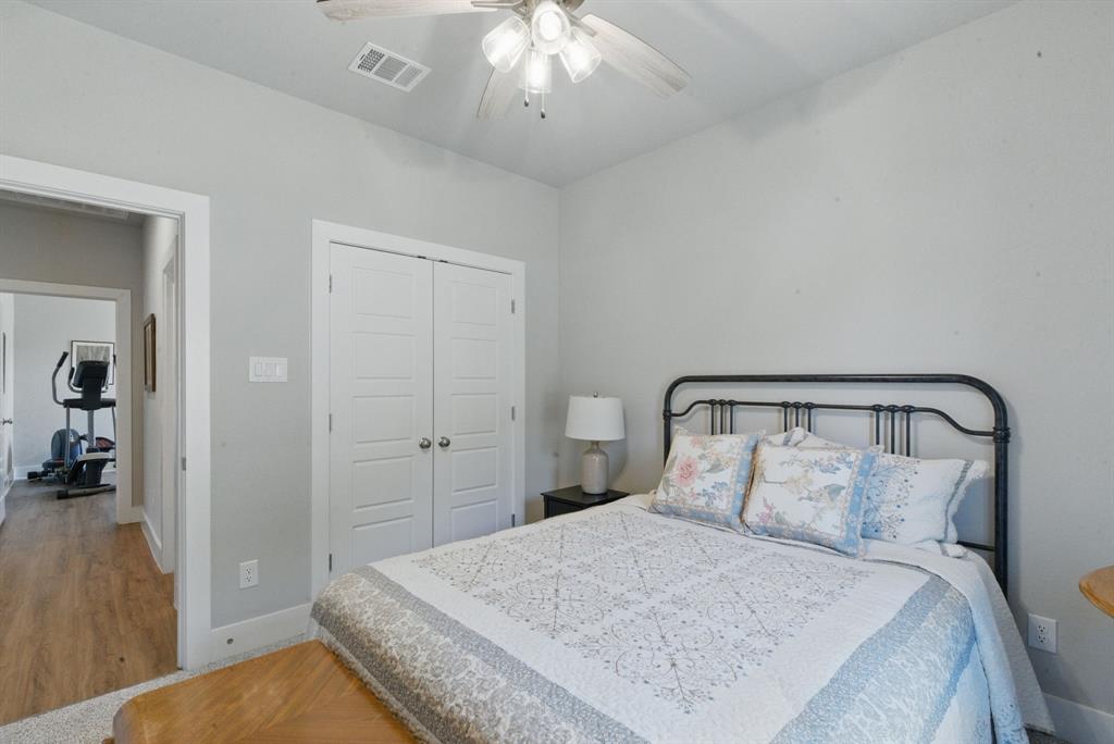 247 Gopher Road Weatherford, TX 76088 - Photo 22 of 35 a bedroom with a large bed and a chandelier