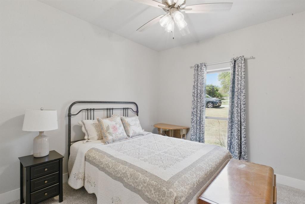 247 Gopher Road Weatherford, TX 76088 - Photo 23 of 35 a bedroom with a bed and a lamp on table