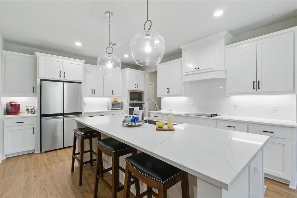 247 Gopher Road Weatherford, TX 76088 - Photo 9 of 35 a kitchen with a refrigerator a stove a sink and white cabinets