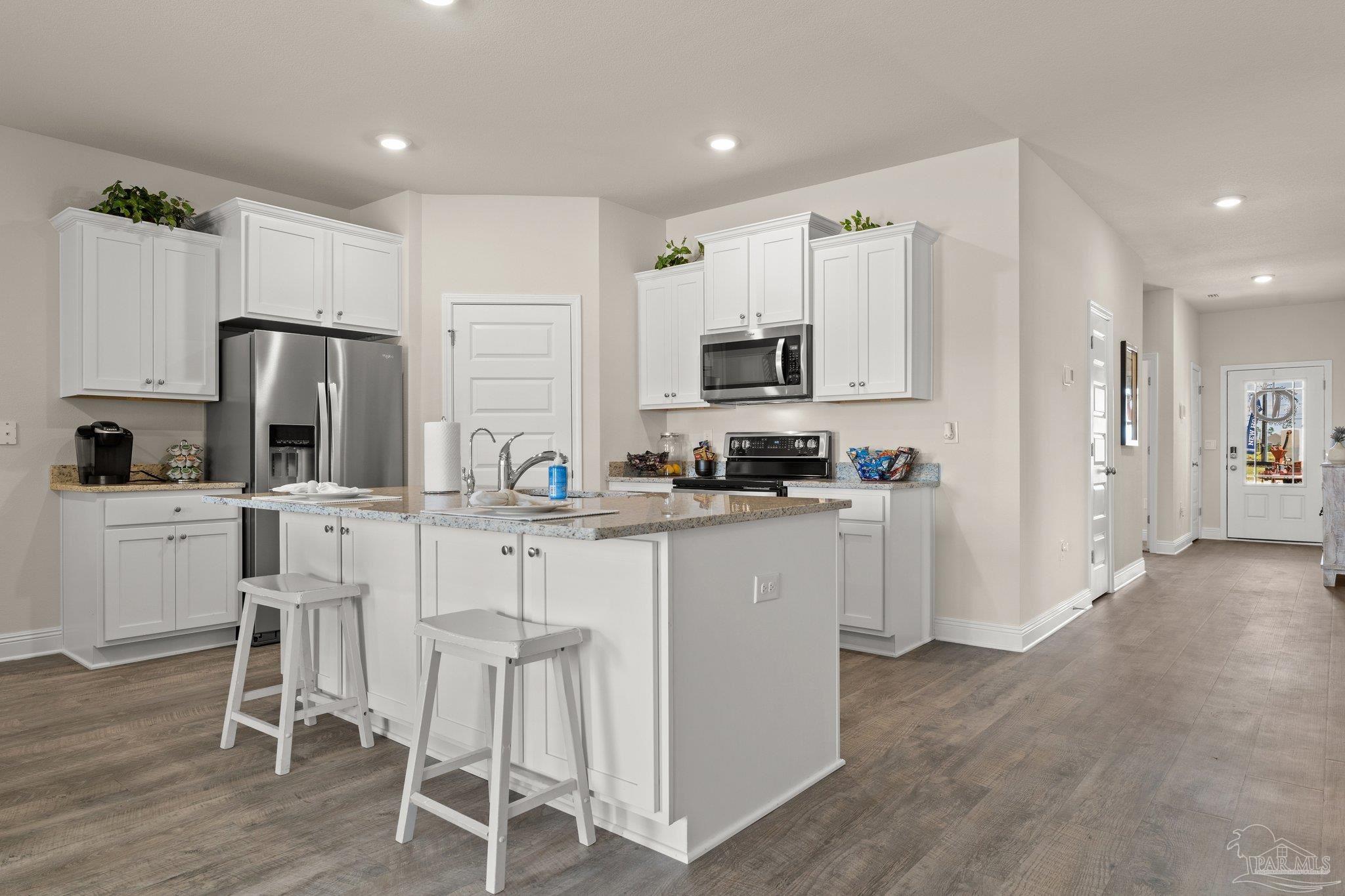 4946 Snipe Road Pace, FL 32571 - Photo 16 of 27 a kitchen with white cabinets and stainless steel appliances