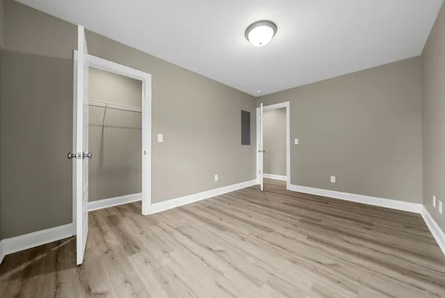 an empty room with wooden floor and closet