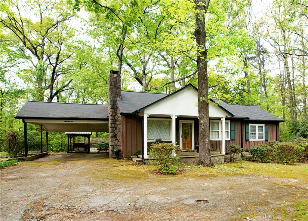 859 Ellis Road Stone Mountain, GA 30083 - Photo 1 of 1 a backyard of a house with table and chairs under an large tree