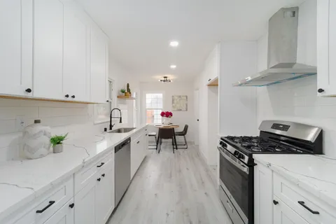 a kitchen with white cabinets sink and white appliances