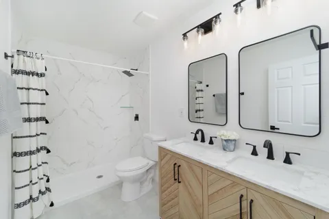 a bathroom with a sink a toilet and shower
