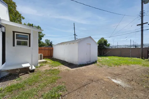 a backyard of a house with a yard and potted plants