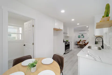 a kitchen with stainless steel appliances kitchen island granite countertop a refrigerator a sink a stove and white cabinets