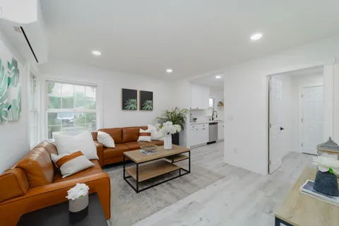 a living room with furniture and wooden floor