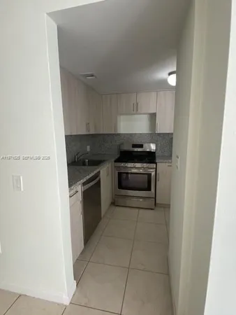 a kitchen with a stove a refrigerator a sink a counter top space and cabinets