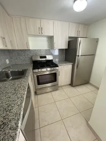 a bathroom with a granite countertop toilet a sink and a mirror