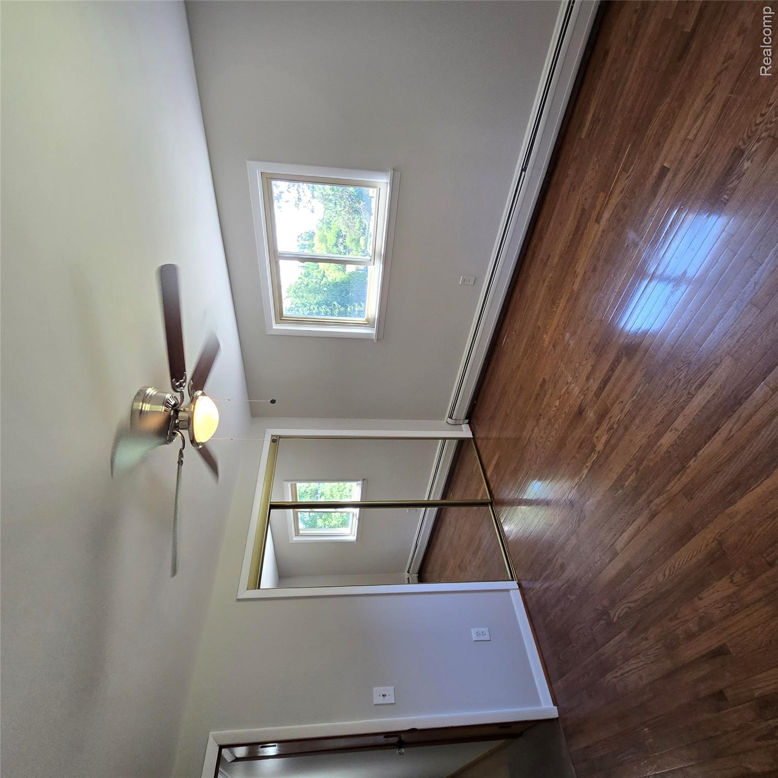 311 Nevada Avenue Rochester, MI 48309 - Photo 36 of 70 Hardwood flooring extending throughout, featuring a ceiling fan with integrated lighting, a mirrored closet, and window with white trim