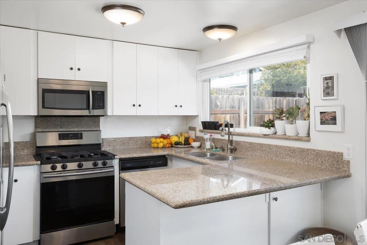 13433 Utopia Road Poway, CA 92064 - Photo 4 of 23 a kitchen with stainless steel appliances granite countertop a sink stove and microwave