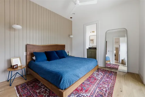 a bedroom with a bed and wooden floor