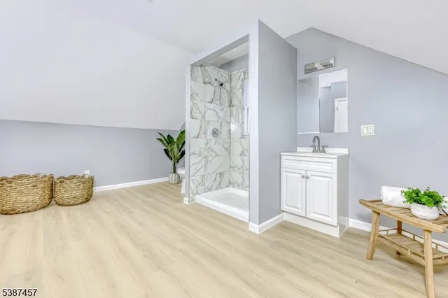 a white room with wooden floor and potted plant