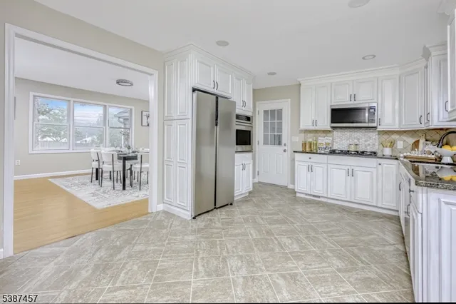 a large kitchen with cabinets and wooden floor