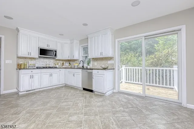 a kitchen with granite countertop a stove a sink and a microwave
