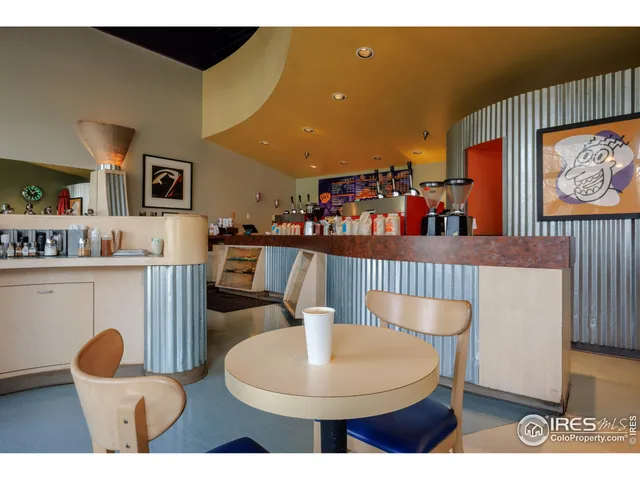 a kitchen with stainless steel appliances a table and chairs