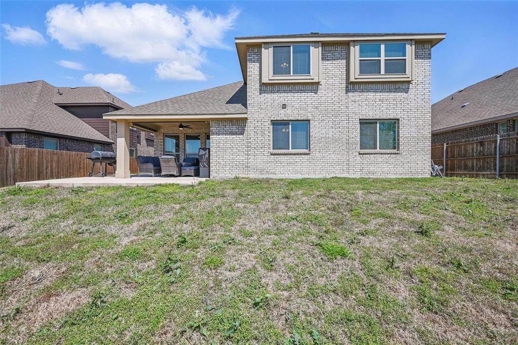 625 Ridgewater Trail Fort Worth, TX 76131 - Photo 26 of 27 Back of house featuring ceiling fan, a fenced backyard, a lawn, a patio, and brick siding