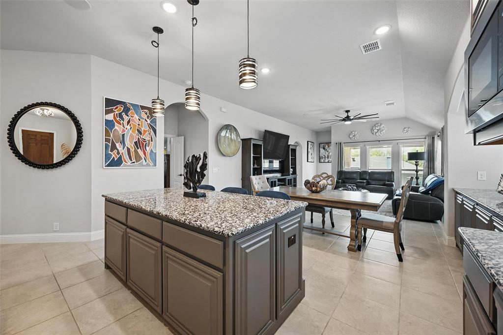 625 Ridgewater Trail Fort Worth, TX 76131 - Photo 5 of 27 Kitchen featuring vaulted ceiling, a kitchen island, built in microwave, ceiling fan, and hanging light fixtures