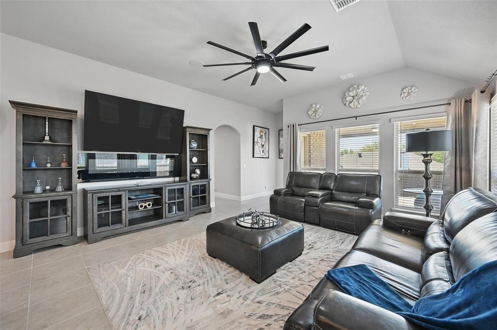 625 Ridgewater Trail Fort Worth, TX 76131 - Photo 9 of 27 Living area featuring ceiling fan, light tile patterned floors, arched walkways, lofted ceiling, and baseboards