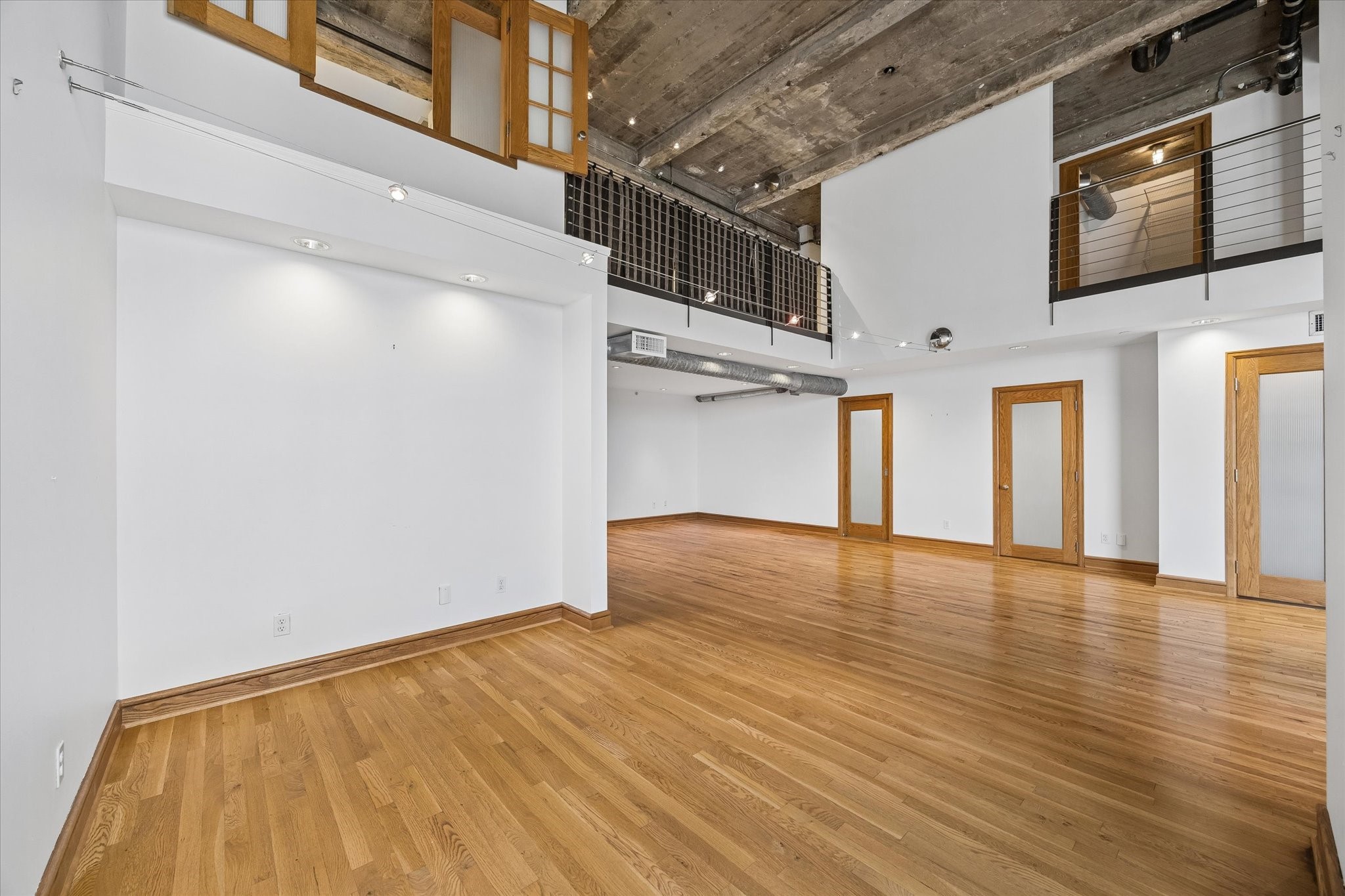 915 Franklin Street, Unit 9L Houston, TX 77002 - Photo 16 of 50 Another angle of the living area featuring high ceilings and the bedroom in the background.