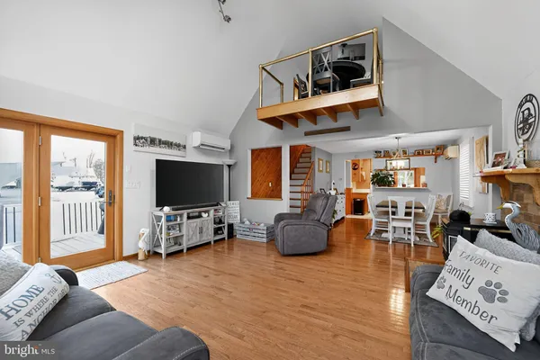 a living room with furniture kitchen view and a chandelier