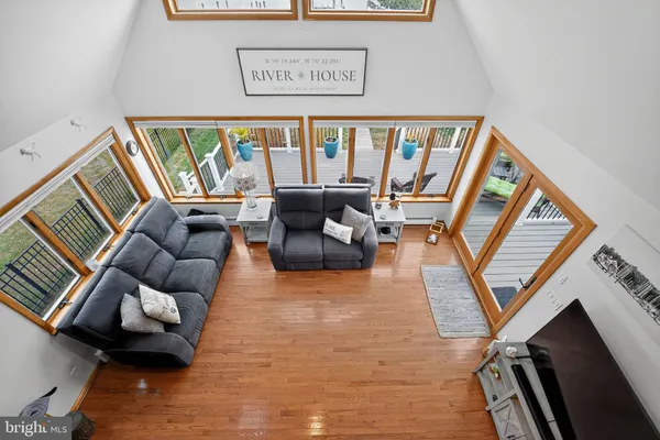 a living room with furniture kitchen view and large windows