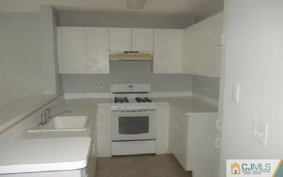824 Edpas Road, Unit 824 New Brunswick, NJ 08901 - Photo 3 of 11 a kitchen with a stove sink and cabinets