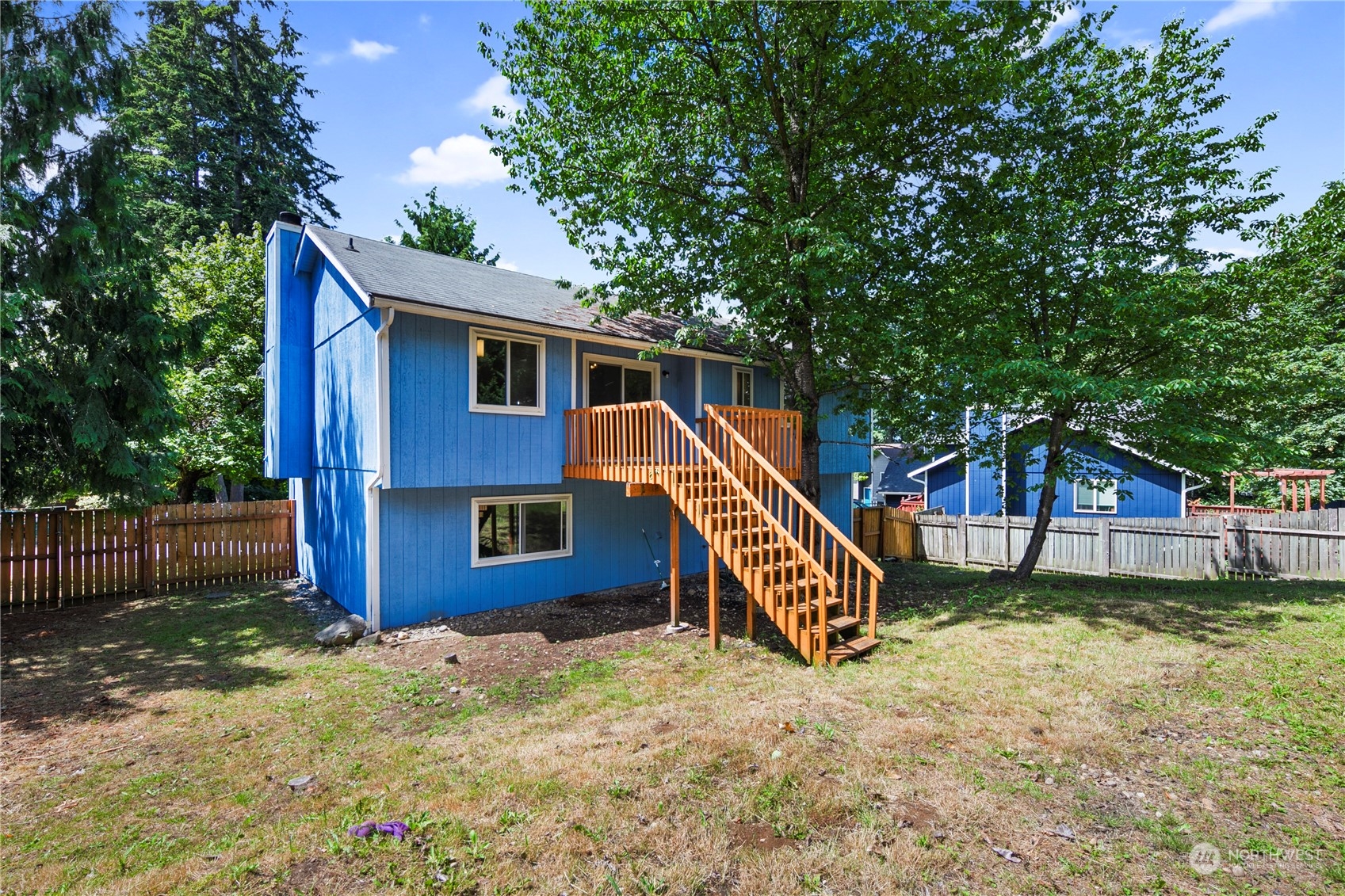 23019 20th Avenue Southeast Bothell, WA 98021 - Photo 28 of 34 a backyard of a house with wooden fence and large trees
