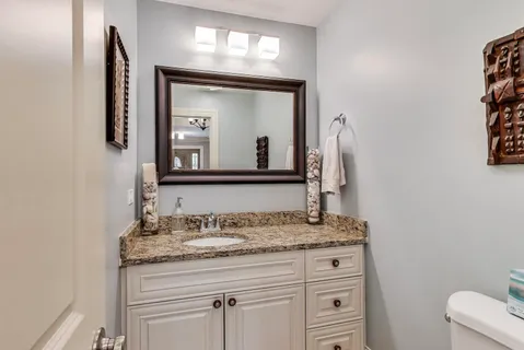 a bathroom with a granite countertop sink a mirror and a vanity