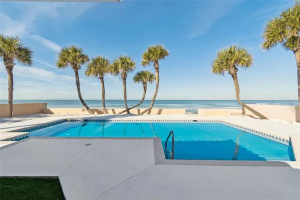 a view of a swimming pool with a lawn chairs under an umbrella