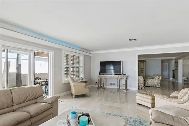 a living room with furniture flat screen tv and large window