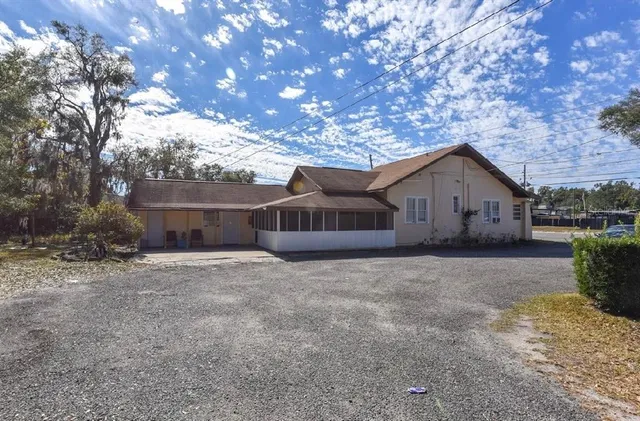 a dirt road with house in the background