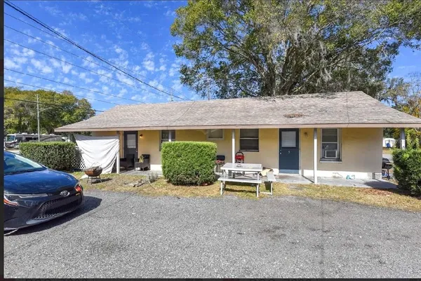 a view of a house with backyard and sitting area