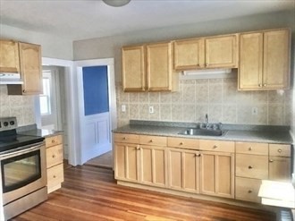107 Wrentham Street, Unit 2 Boston, MA 02124 - Photo 10 of 11 a kitchen with granite countertop a sink cabinets stainless steel appliances and a window
