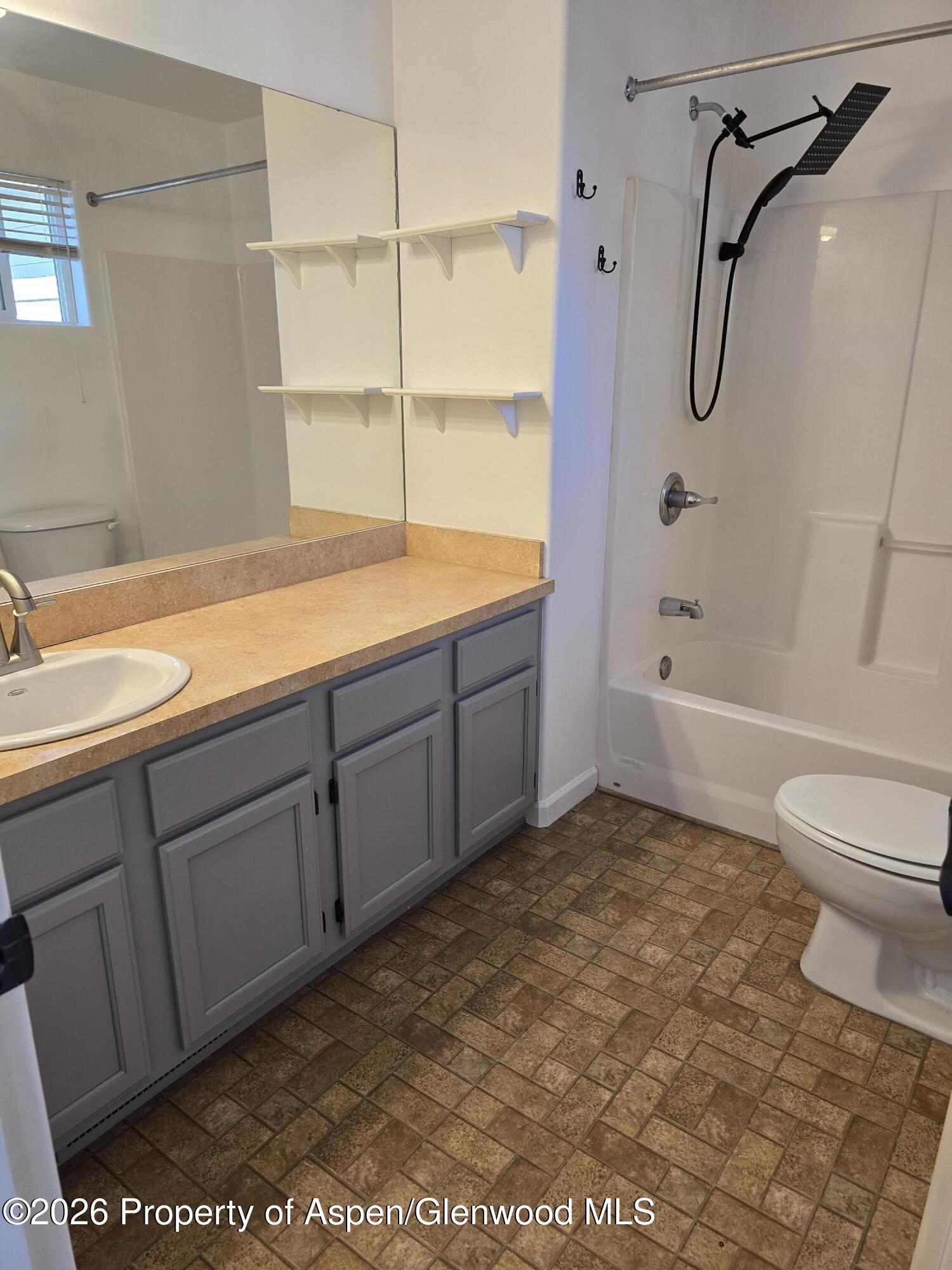145 West 26th Street Rifle, CO 81650 - Photo 5 of 7 a bathroom with a granite countertop sink a toilet and bathtub