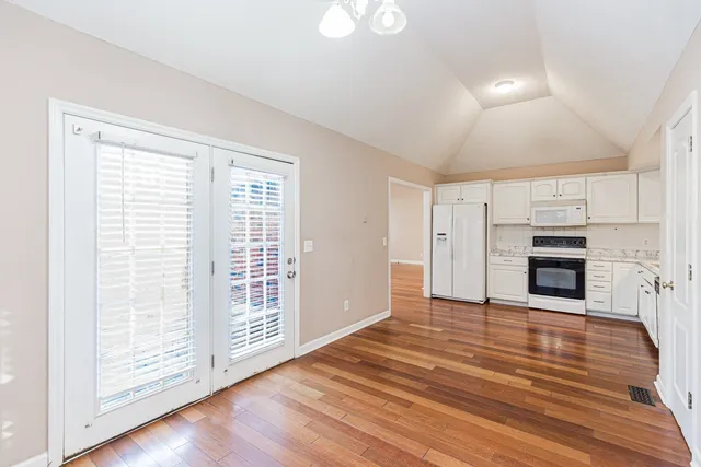 a view of empty room with wooden floor and fireplace