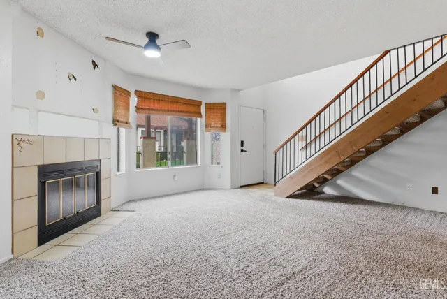 a view of an empty room with a fireplace and a window