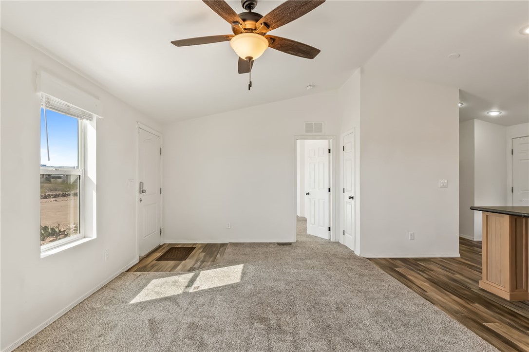 3534 Eloy Road Golden Valley, AZ 86413 - Photo 6 of 58 Living room featuring lofted ceiling, dark colored carpet, and ceiling fan