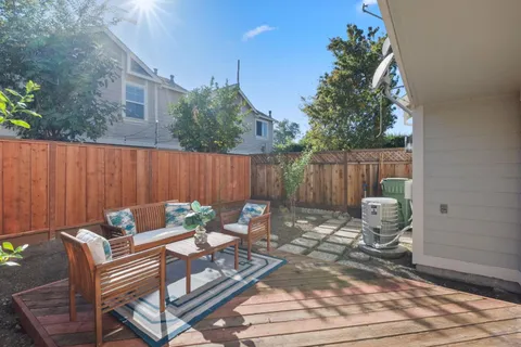 a view of a patio with a dining table and chairs with wooden fence